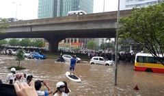 Người dân chèo thuyền trên đường vành đai 3 trong trận mưa ngày 25/5/2016