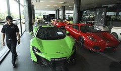 Một viên cảnh sát kiểm tra tại showroom kinh doanh siêu xe đã qua sử dụng bị nghi ngờ buôn lậu ở Thái Lan. Ảnh: Bangkok Post