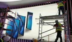 Các công nhân đang thi công poster quảng cáo điện thoại Huawei Mate X (ảnh: Phone Arena)