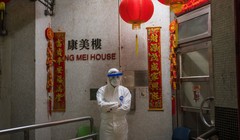 Một nhân viên y tế mặc đồ bảo hộ đứng bảo vệ bên ngoài lối vào tòa nhà chung cư ở Tsing Yi (Hồng Kông) sau khi phát hiện cư dân thứ hai nhiễm virus tại đây. Hơn 100 người sống tại tòa chung cư này đã được sơ tán (ảnh Getty Images)