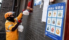 Một lái xe công nghệ nhận đồ ăn qua cửa sổ từ một nhà hàng ở Bắc Kinh