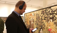 Khách thăm quan xem thông tin tác phẩm trên app iMuseum VFA tại Bảo tàng Mỹ thuật Việt Nam