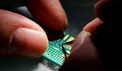 Một kỹ sư đặt chip bán dẫn lên bo mạch trong quá trình nghiên cứu thiết kế và phát triển sản phẩm bán dẫn tại Trung tâm Thanh Hoa Unigroup ở Bắc Kinh, Trung Quốc, ngày 29 tháng 2 năm 2016 (ảnh Reuters)