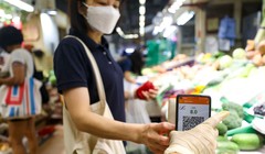 Một người phụ nữ sử dụng app thanh toán Octopus của mình để mua hàng tại chợ Sai Ying Pun (ảnh: Xiaomei Chen)