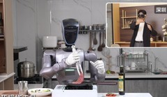 Robot hình người chế biến bít tết thông qua một người điều khiển từ khoảng cách 1.800 km. Ảnh: SCMP
