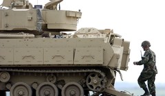 Một người lính đang đi bộ phía sau chiếc xe Bradley Fighting Vehicle trong cuộc diễn tập tại Fort Riley, Kansas (Ảnh Getty Images)