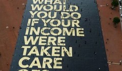 Tháng trước, những người ủng hộ đề xuất thu nhập cơ bản hàng tháng được đảm bảo ở Thụy Sỹ đã chuẩn bị một áp phích lớn với nội dung: "Các bạn sẽ làm gì nếu thu nhập của các bạn được chăm sóc?" - Ảnh: Reuters/BBC.