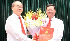 Bí thư Thành ủy TPHCM Nguyễn Thiện Nhân trao quyết định và hoa chúc mừng ông Vũ Ngọc Tuất.