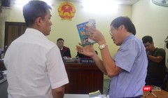 Họa sĩ Lê Linh (áo trắng) và ông Nguyễn Vân Nam (người đang cầm cuốn sách) - đại diện cho công ty Phan Thị với những trao đổi gay gắt tại tòa 