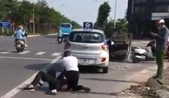 Hình ảnh từ video clip cho thấy Đại uý Công an gọi điện thoại trong khi người lái taxi vật lộn với tên cướp - Ảnh cắt từ clip