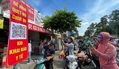 Người dân quét mã khai báo y tế trên điện thoại tại trạm kiểm soát trên đường Nguyễn Kiệm (Gò Vấp) ngày 7/6 (Ảnh: SGGP) 