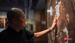 Họa sĩ Trần Ngọc Hưng bên những tác phẩm đang trưng bày tại Ngõ Art Gallery. Ảnh: Phạm Nguyễn 