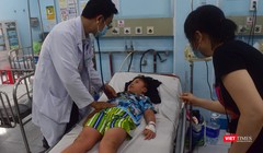 TS.BS Nguyễn Minh Tuấn thăm khám bệnh nhi sốt xuất huyết phải chuyển viện từ BV Quận 12 đến BV Nhi Đồng 1- Ảnh: Hòa Bình