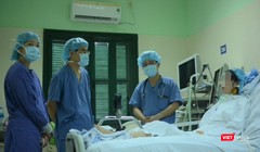 Bác sĩ giúp chị H. tập phục hồi chức năng tại giường (Ảnh: Quang Hùng)