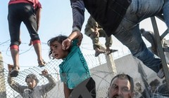 Người tị nạn Syria vượt qua hàng rào dây thép gai tại biên giới Thổ Nhĩ Kỳ. 