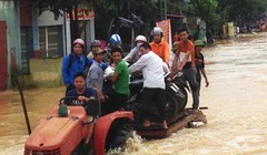 Tại Thanh Hóa, người dân dùng xe công nông để vận chuyển người và phương tiện qua đoạn ngập. Ảnh: L.H/ VnE