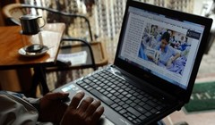 Một người đàn ông đang đọc tin trên mạng bằng laptop trong một quán cafe ở Hà Nội. Ảnh minh hoạ: AFP