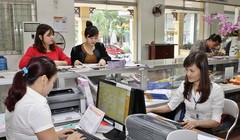 Giao dịch viên phục vụ khách hàng từ mùng Ba Tết. Ảnh: Minh Đàm