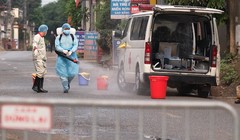 Lực lượng chức năng phun khử khuẩn phía trước ngôi nhà bệnh nhân 243. Ảnh: CDC Hà Nội.