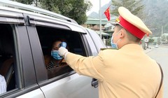 Công an TP Cẩm Phả vừa điều tiết giao thông vừa kết hợp với đo nhiệt độ người tham gia giao thông. Ảnh: UBND tỉnh Quảng Ninh.