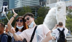 Du khách chụp ảnh tại công viên Merlion, Singapore (Ảnh: SCMP)
