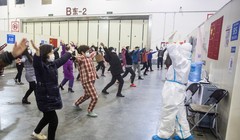 Nhân viên y tế trong trang phục bảo hộ kín mít hướng dẫn các bệnh nhân tập thể dục (Ảnh: Getty)