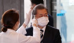 Tổng thống Hàn Quốc Moon Jae-in được đeo khẩu trang và kiểm tra thân nhiệt trước khi vào tòa nhà Quốc hội ở Seoul trong hôm 28/2 (Ảnh: Yonhap)