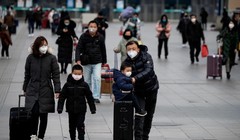 Nhiều hành khách mang khẩu trang chống COVID-19 tại trạm đường sắt ở Bắc Kinh (Ảnh: AFP)