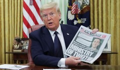 Tổng thống Trump cầm tờ New York Times lúc phát biểu trước phóng viên trong khi chuẩn bị ký sắc lệnh mới (Ảnh: Reuters)