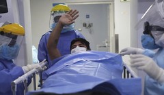 Một bệnh nhân được chuyển ra khỏi khu điều trị đặc biệt ở Lima, Peru (Ảnh: AP)