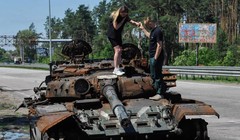 Một cặp đôi tò mò đứng trên chiếc xe tăng Nga bị phá hủy ở Kiev, Ukraine (Ảnh: DPA)