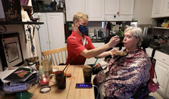 Nhân viên chăm sóc Andrew Wolfram giúp bà Karen Foxgiver ăn trưa bên trong căn hộ của bà (Ảnh: Madison)