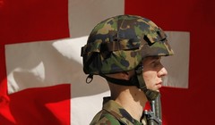 Một người lính Thụy Sĩ đứng trước lá quốc kỳ (Ảnh: Getty)