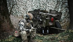 Một quân nhân Nga ngồi cạnh một khẩu pháo ở Vùng Kursk, Nga ngày 5/11 (Ảnh: Sputnik)