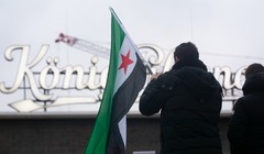 Người Syria tị nạn phản ứng trước những diễn biến mới ở Syria tại Ga trung tâm Duisburg ở Duisburg, Đức. Ảnh: Getty.