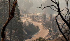 Một chiếc ô tô bị cháy nằm giữa tàn tích của những ngôi nhà sau vụ cháy Palisades ở khu Pacific Palisades, Los Angeles, California, Mỹ. Ảnh: Reuters.