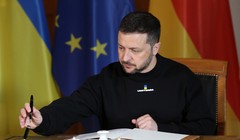 Tổng thống Ukraine Volodymyr Zelensky đang ký vào một cuốn sổ lưu bút. Ảnh: Getty.