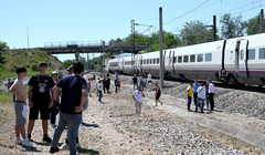 Hành khách đứng cạnh một chuyến tàu dừng lại gần Cordoba, Tây Ban Nha. Ảnh: AFP