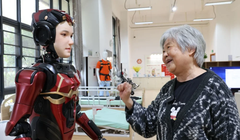 Một cư dân cao tuổi tại một viện dưỡng lão ở Thâm Quyến đang tương tác với một robot hình người. Ảnh: Xinhua.