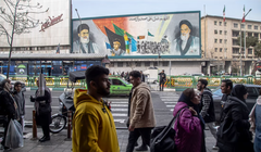 Người dân Iran đi bộ dọc theo các con phố ở Tehran, Iran, vào ngày 24/2/2024. Một bức tranh tường trên Đại lộ Enqelab có hình ảnh nhà Lãnh tụ tối cao Ali Khamenei. Ảnh: AFP.