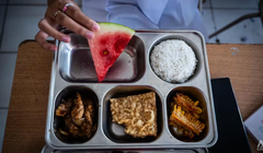 Một học sinh trung học cơ sở ở Bandung, Indonesia cùng khay thức ăn được cung cấp như một phần trong chương trình bữa ăn miễn phí của nước này. Ảnh: CNA.