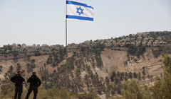 Lá cờ Israel tung bay, một phần của khu định cư Maale Adumim của Israel có thể được nhìn thấy ở phía sau, tại khu Bờ Tây do Israel chiếm đóng, ngày 14/8. Ảnh: Reuters.