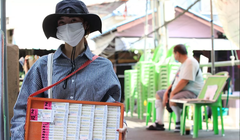 Một người bán vé số tại đường Ti Thong ở Bangkok, Thái Lan. Ảnh: Bangkok Post.