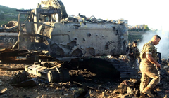 Binh sĩ Lebanon đi cạnh một máy đào bị phá hủy sau cuộc không kích của Israel. Ảnh: AFP.