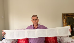 Laurence Watkins, một nhân viên bảo vệ đã nghỉ hưu đến từ Auckland, New Zealand, cầm trên tay giấy khai sinh dài 6 trang, trong đó ghi đầy đủ 2.253 cái tên của ông. Ảnh: CNN.