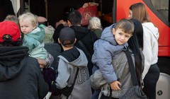 Người tị nạn từ Ukraine đứng cạnh một chiếc xe buýt tại trung tâm tiếp nhận người tị nạn đầu tiên ở Hesse, Đức. Ảnh: Getty.
