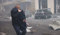 Một người đàn ông đưa đứa trẻ ra khỏi hiện trường một vụ tấn công tại Kharkov, Ukraine ngày 22/10. Ảnh: Reuters.