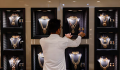 Một nhân viên đang sắp xếp vòng cổ vàng tại một cửa hàng trang sức ở Mumbai, Ấn Độ, ngày 20/3. Ảnh: Reuters.