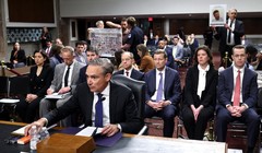 Tổng giám đốc điều hành Boeing Kelly Ortberg làm chứng trước một ủy ban Thượng viện khi những người biểu tình giơ cao các tấm biển mô tả các nạn nhân của vụ tai nạn 737 MAX. Ảnh: Getty.