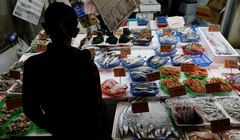 Một khách hàng đang xem hải sản tại một cửa hàng ở Tokyo, Nhật Bản ngày 19/11. Ảnh: Reuters.